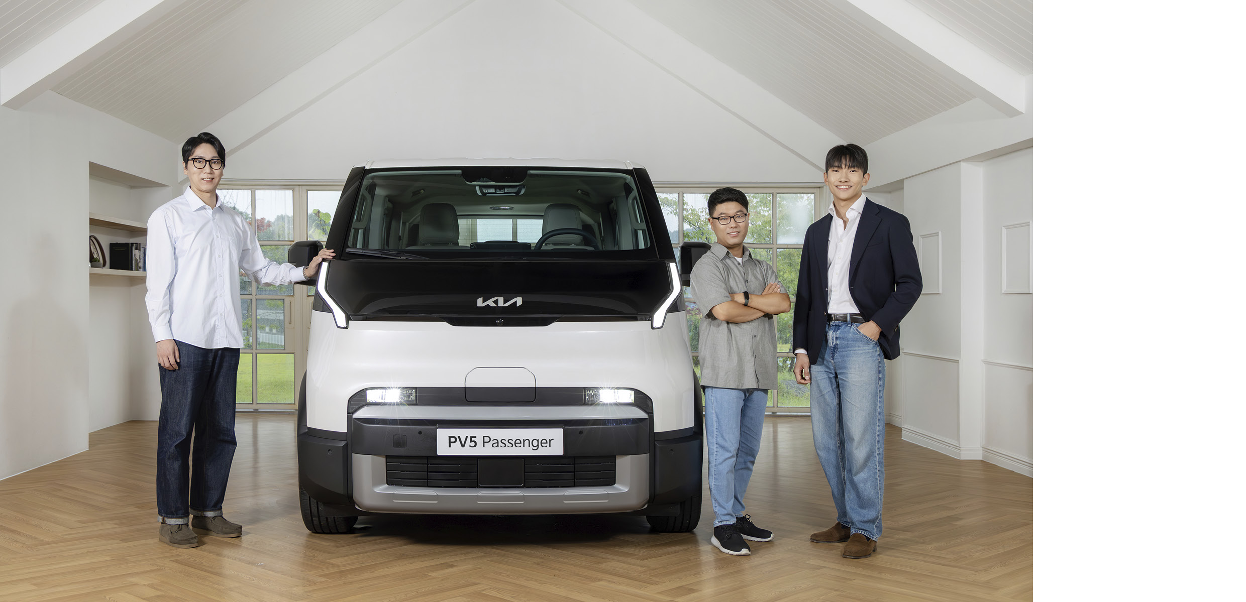 기아 PV5와 함께 서 있는 연구원들의 모습
