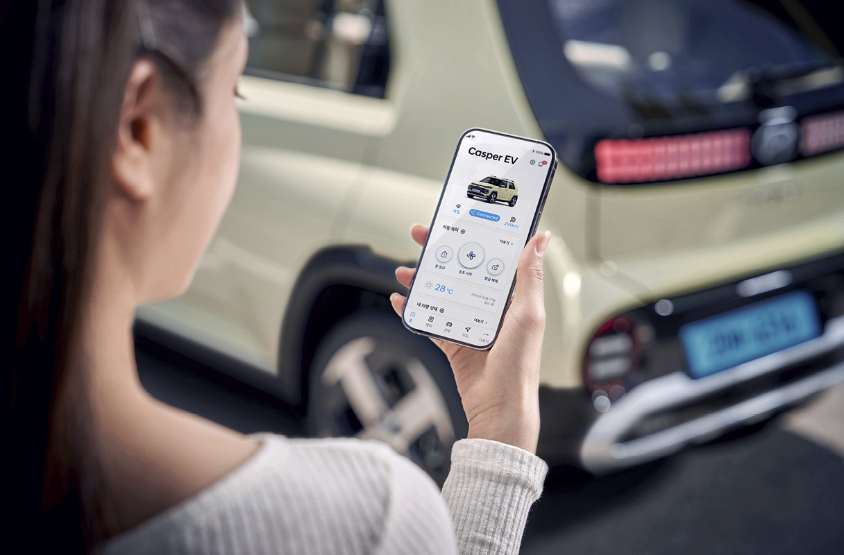 앱으로 전기차를 조작하고 있는 여성의 모습