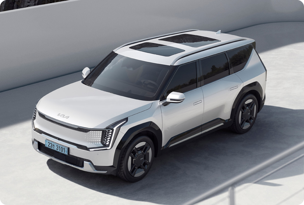 EV9이 흰색 건축물 배경으로 정차한 모습