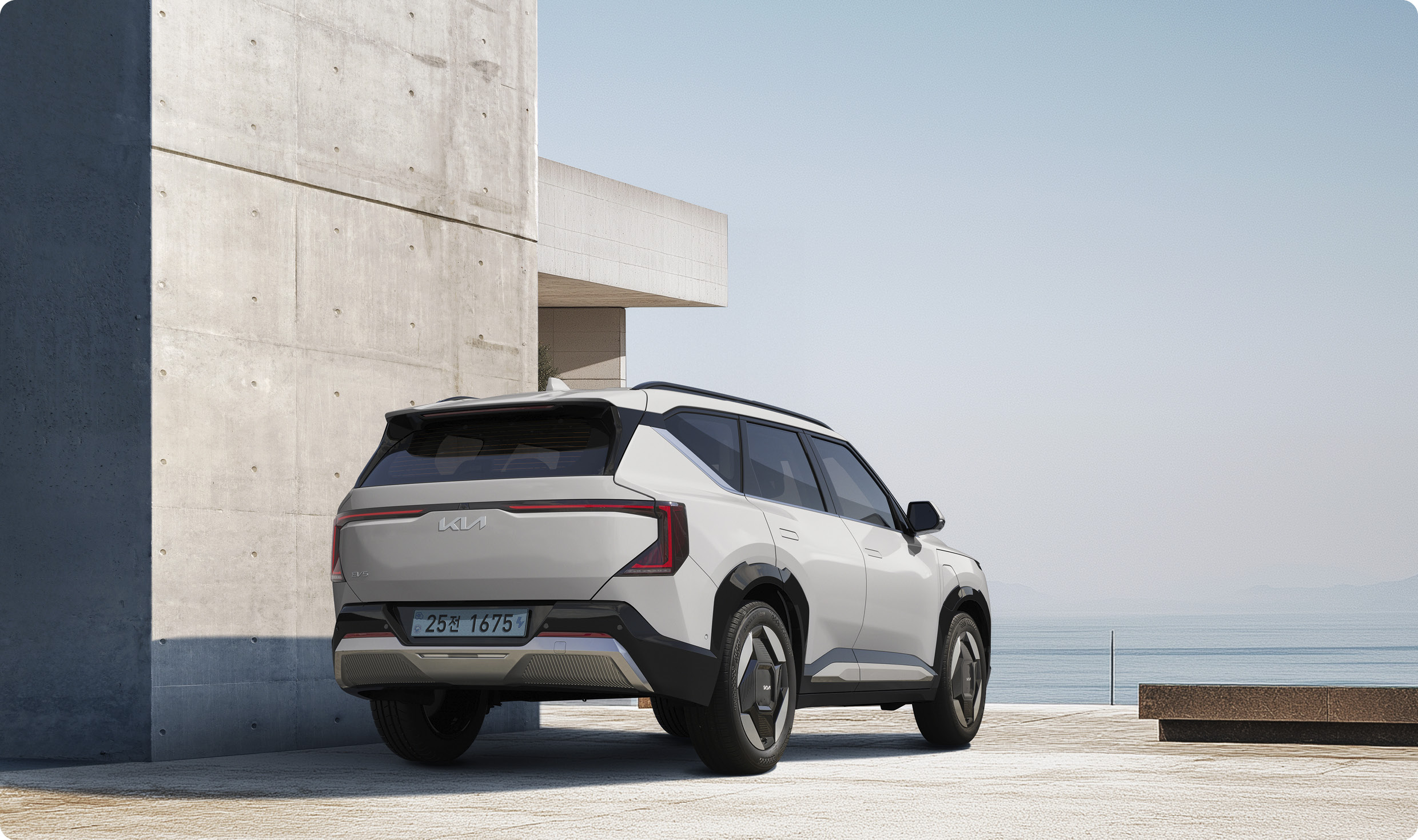 EV5가 콘크리트 건축물 옆에 후측면 방향으로 정차한 모습