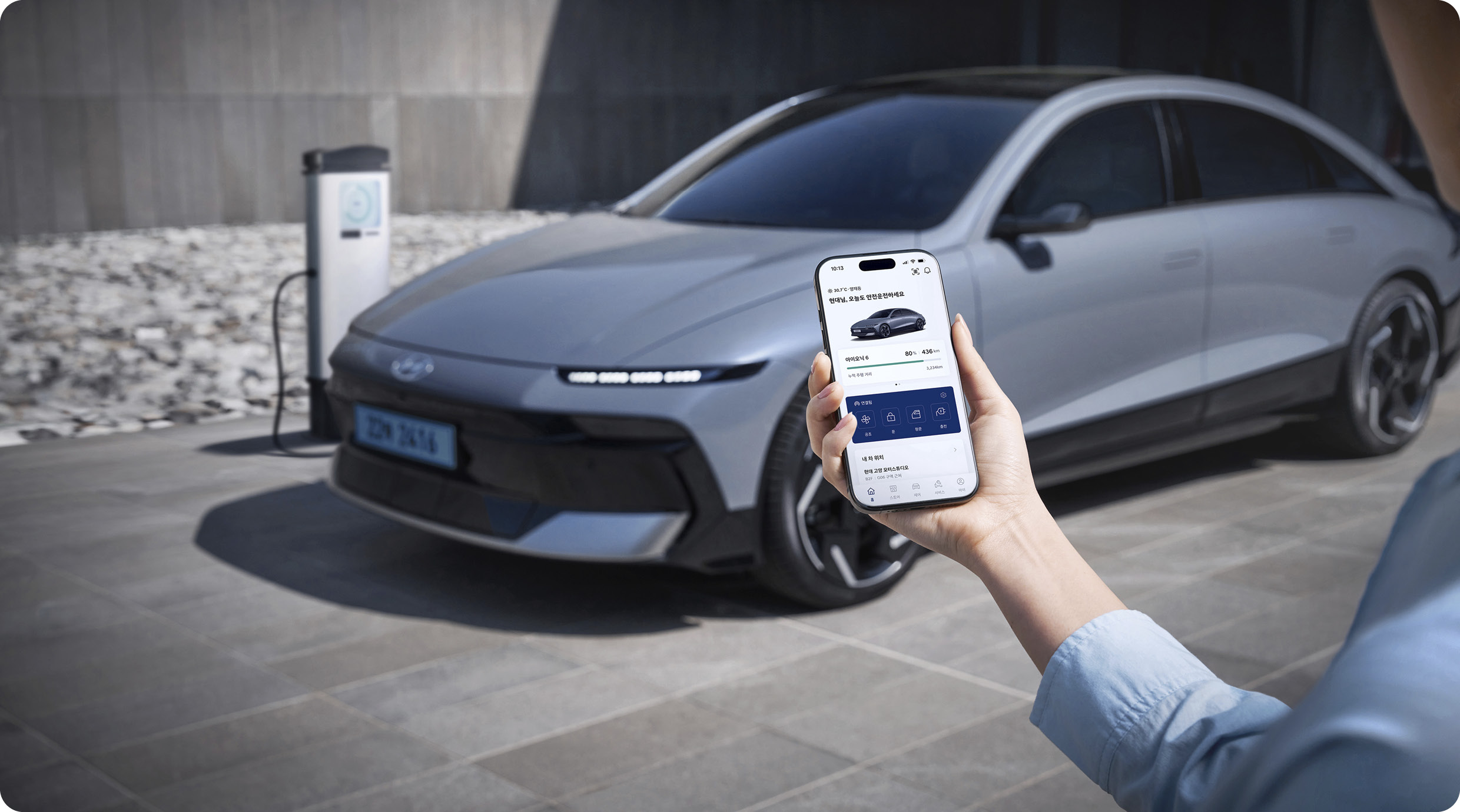 차량 앞에서 스마트폰을 조작하는 모습