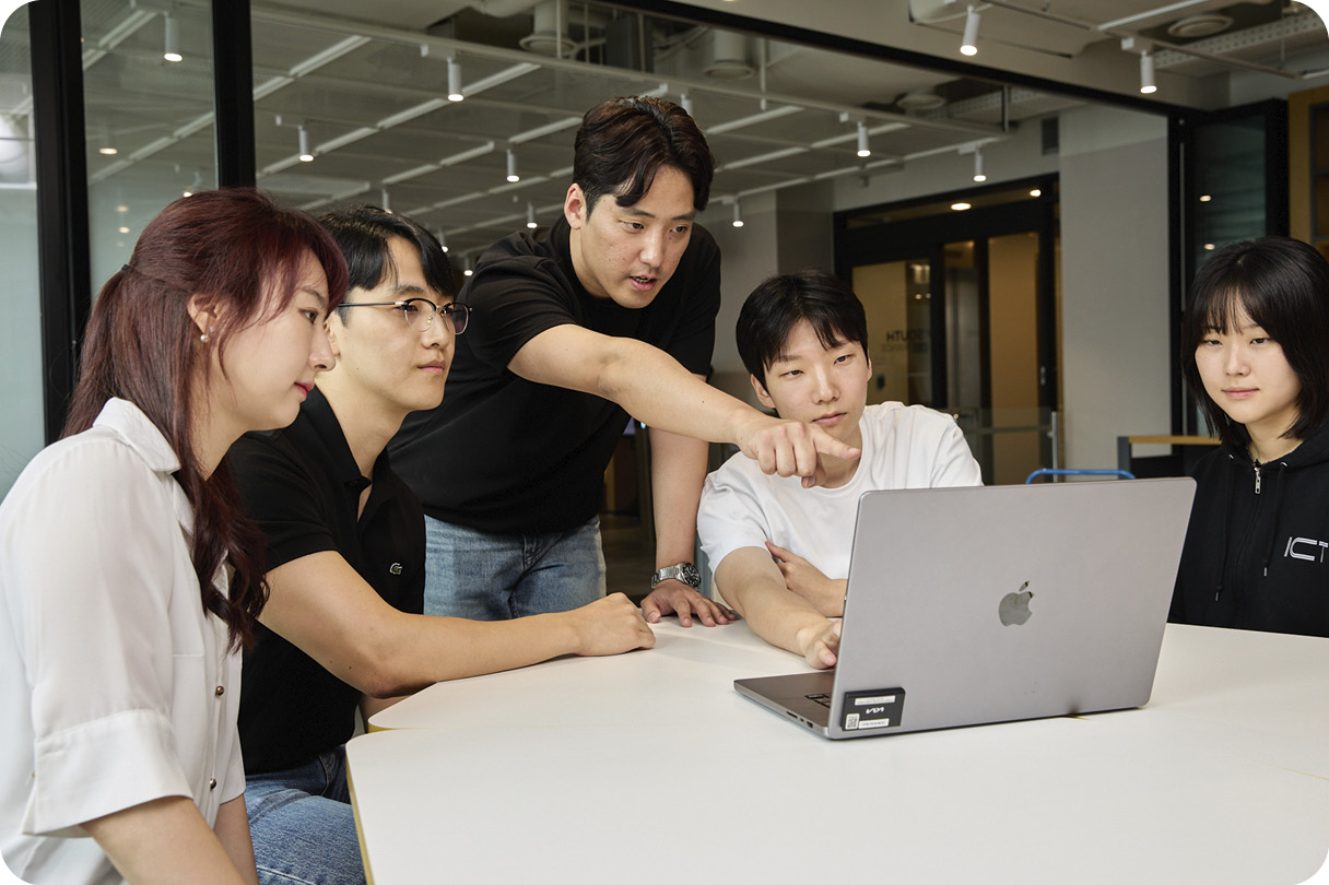 ICT본부 직원들이 노트북 화면을 보며 업무 이야기를 나누고 있다