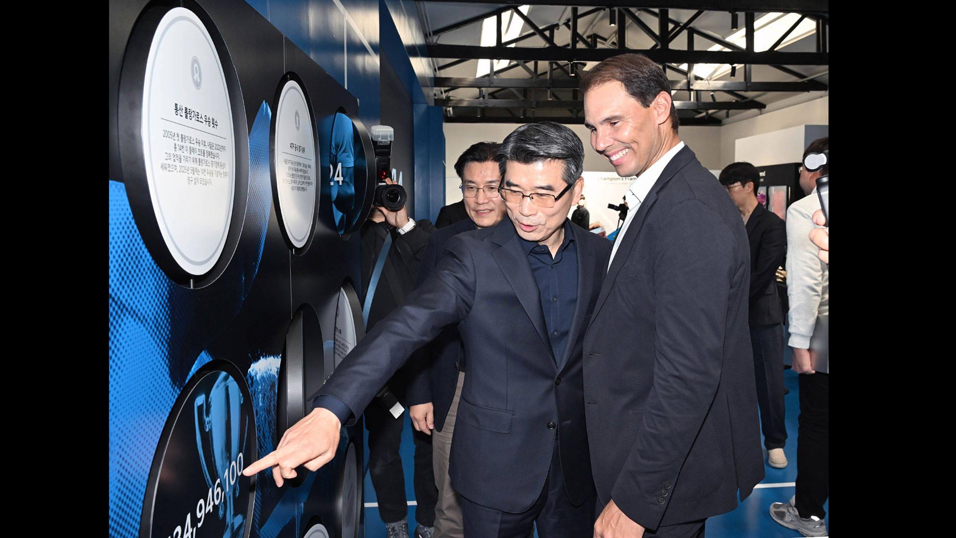 기아 송호성 사장과 라파엘 나달이 조인식이 열린 기아 언플러그드 그라운드 내 파트너십 관련 전시물을 함께 관람하고 있는 모습