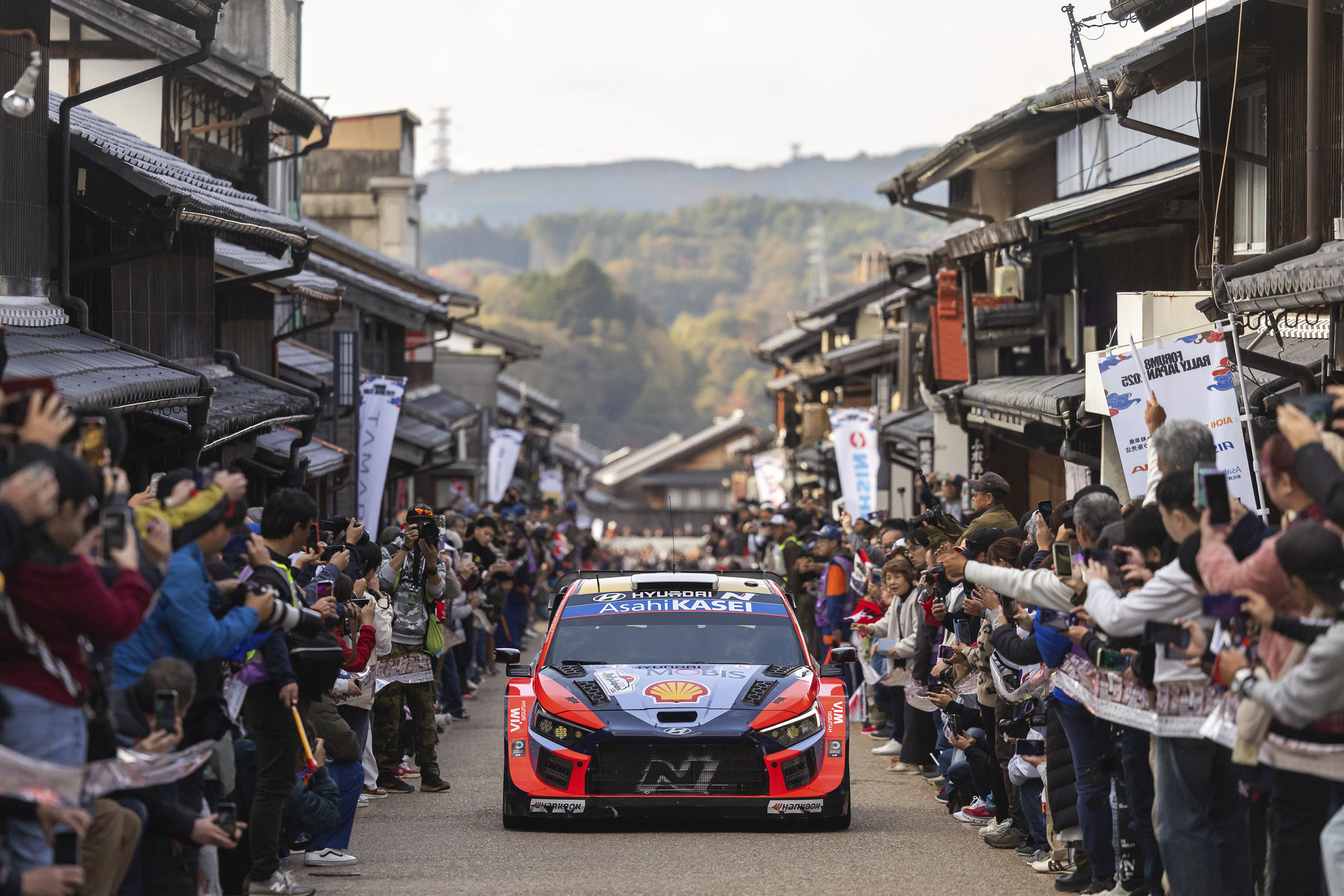 Hyundai Team Rally Car Driving Between Japanese Rally Spectators