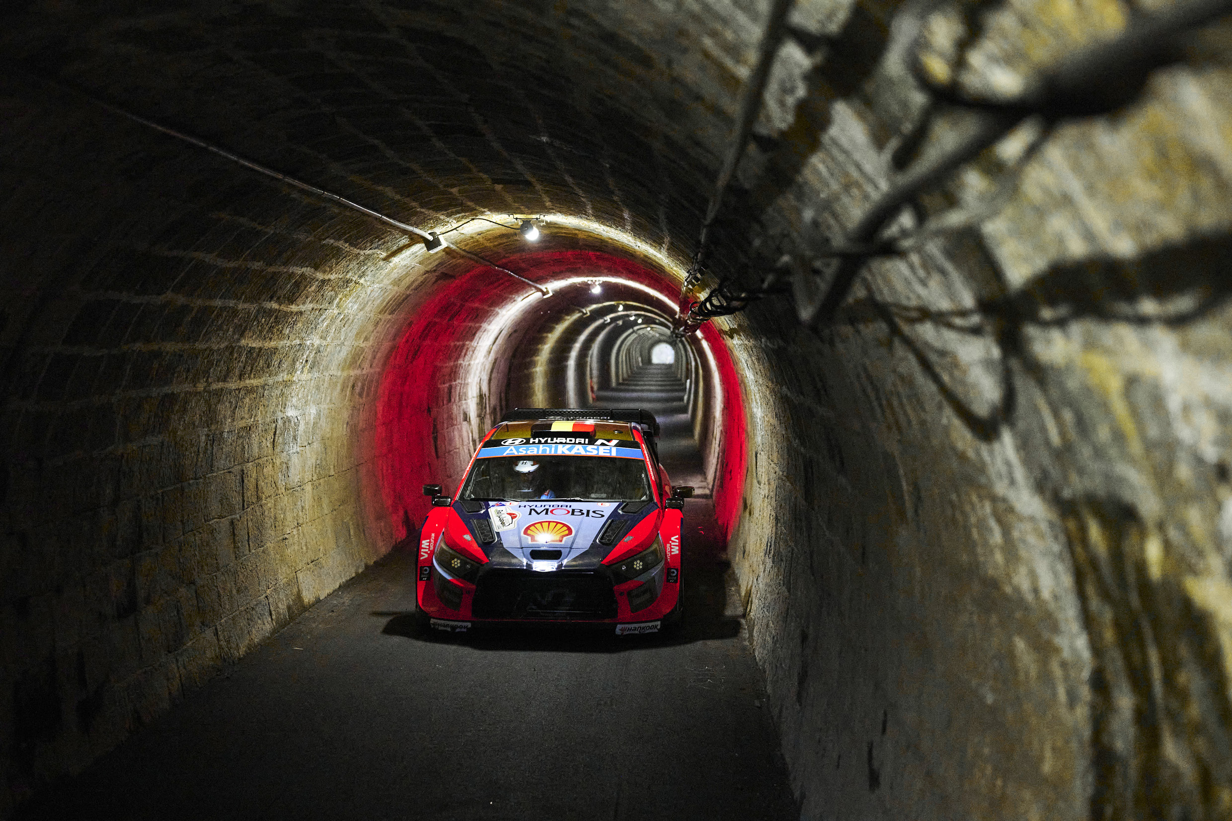 Front view of Hyundai team rally car driving through tunnel