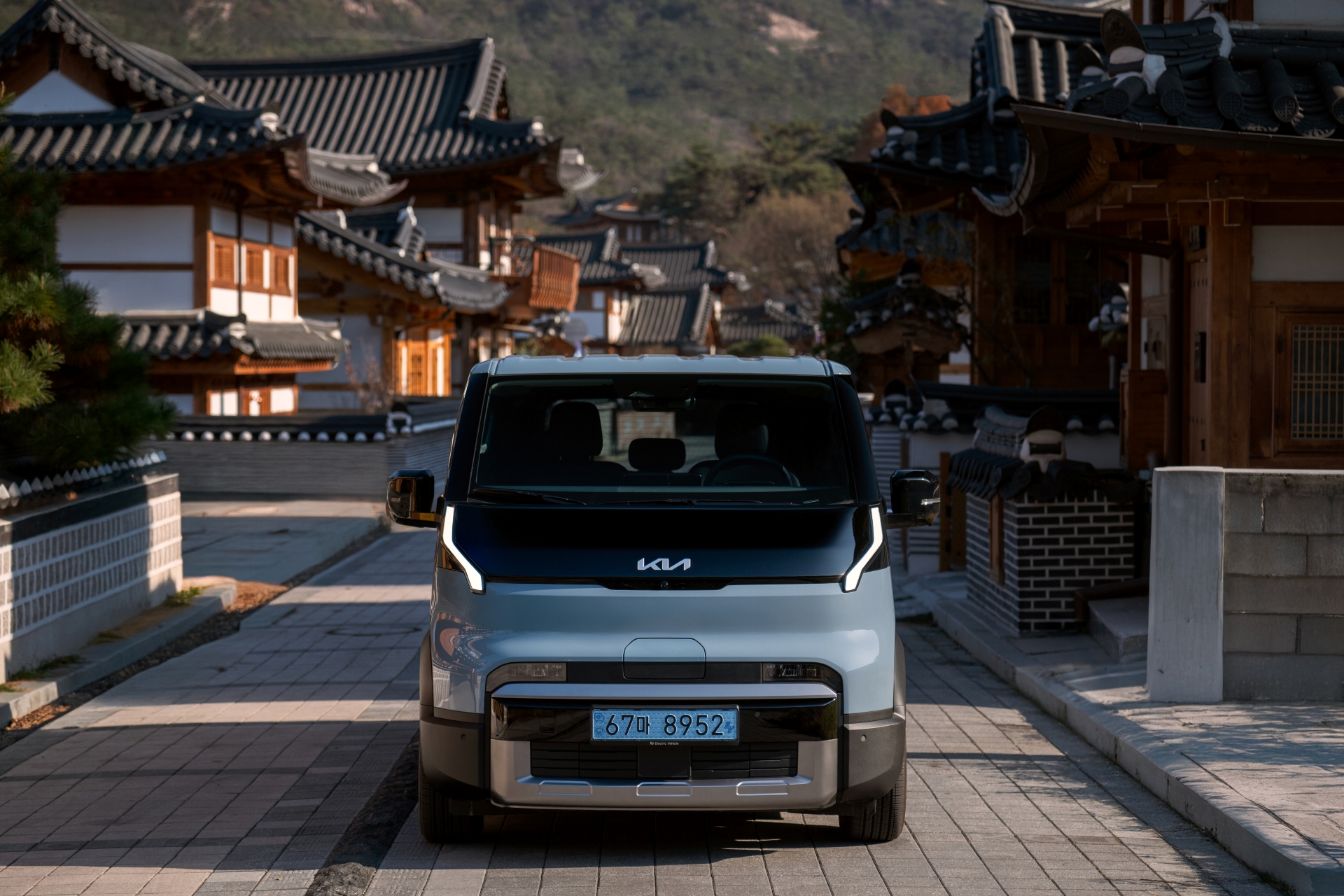 The Kia PV5 brings a sense of ease to quiet autumn paths, framed by warm, shifting colors.