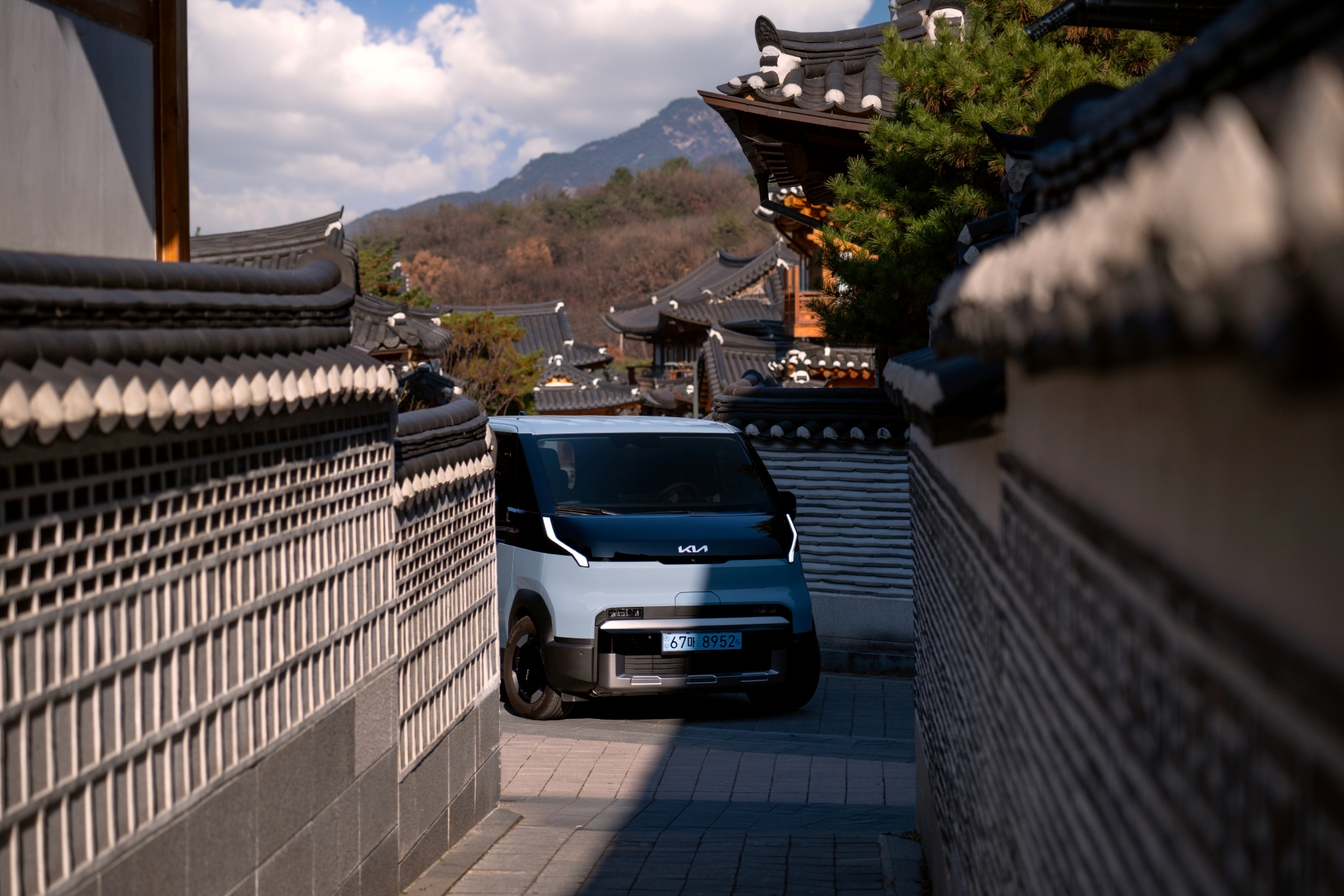 The Kia PV5 brings a sense of ease to quiet autumn paths, framed by warm, shifting colors.