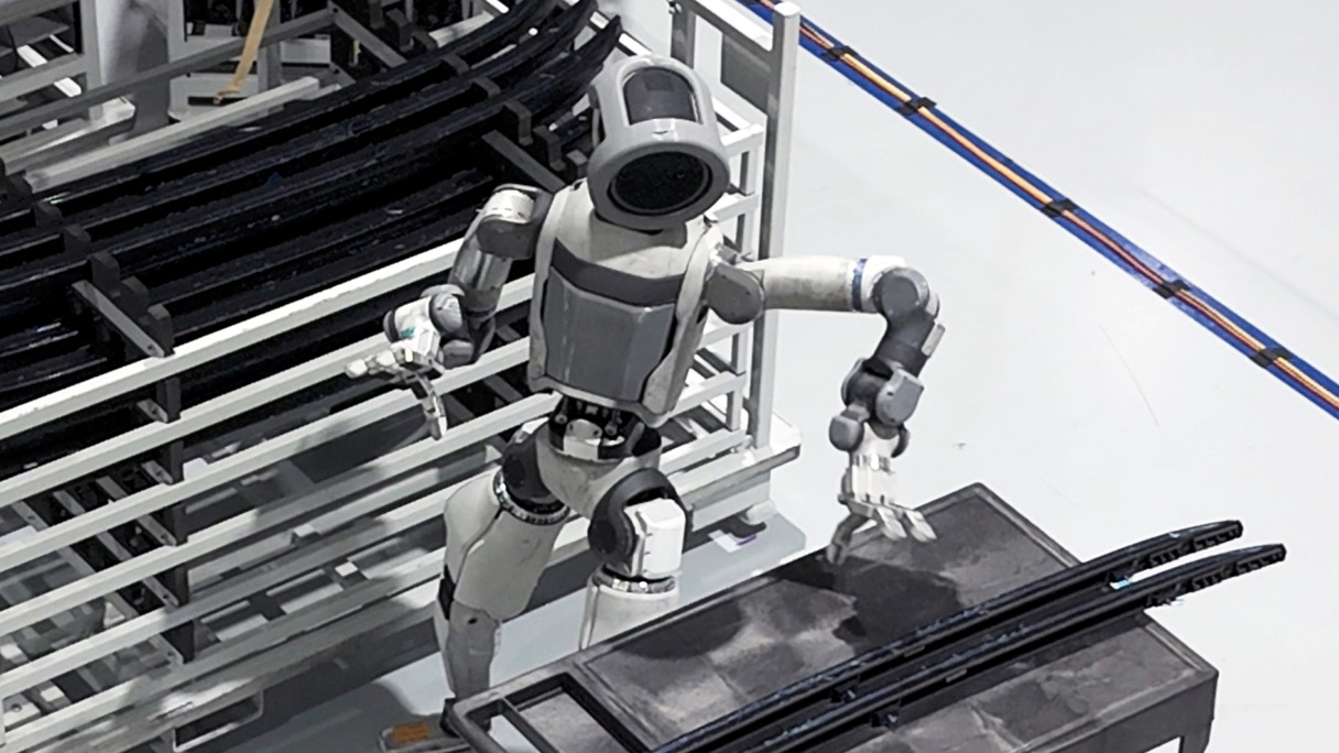 기계 부품 점검을 위해 뚜껑을 열고 있는 아틀라스 로봇