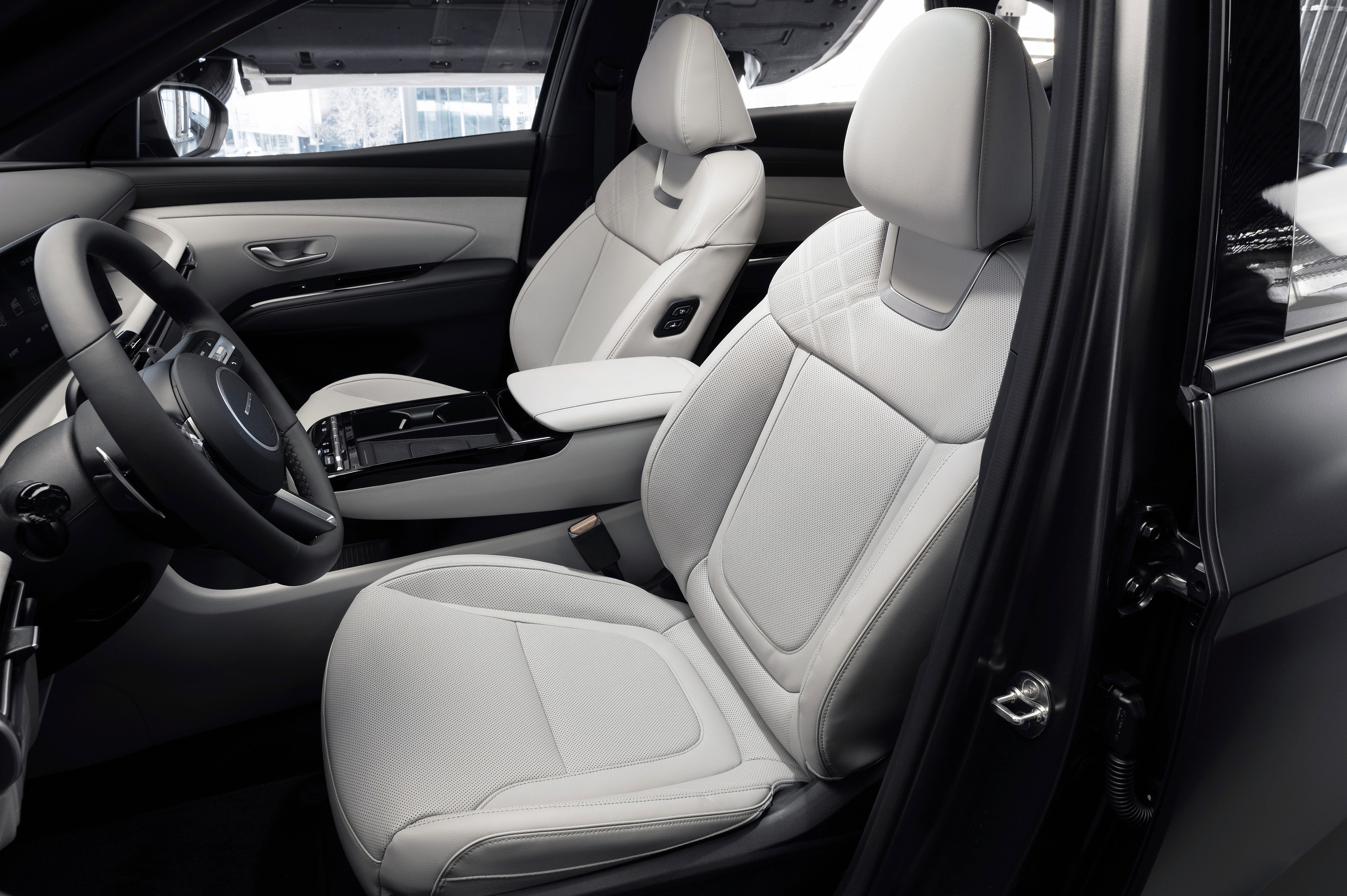 투싼 차량 내장 앞좌석 (시트, 센터콘솔, 스티어링 휠).