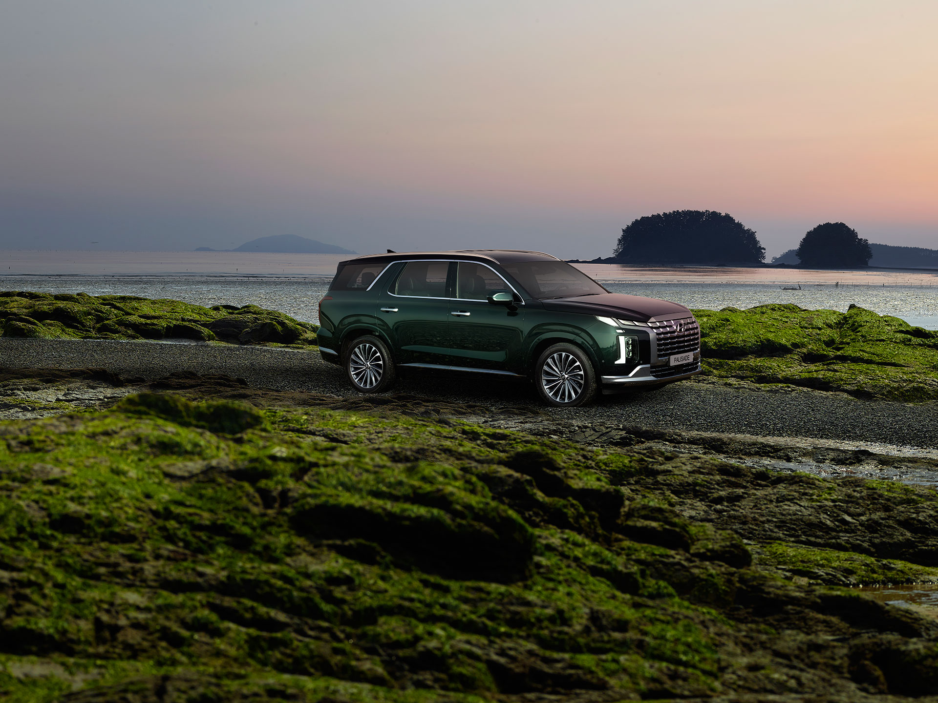 노을 진 해변가에서 서 있는 현대자동차 팰리세이드 SUV 차량의 측면