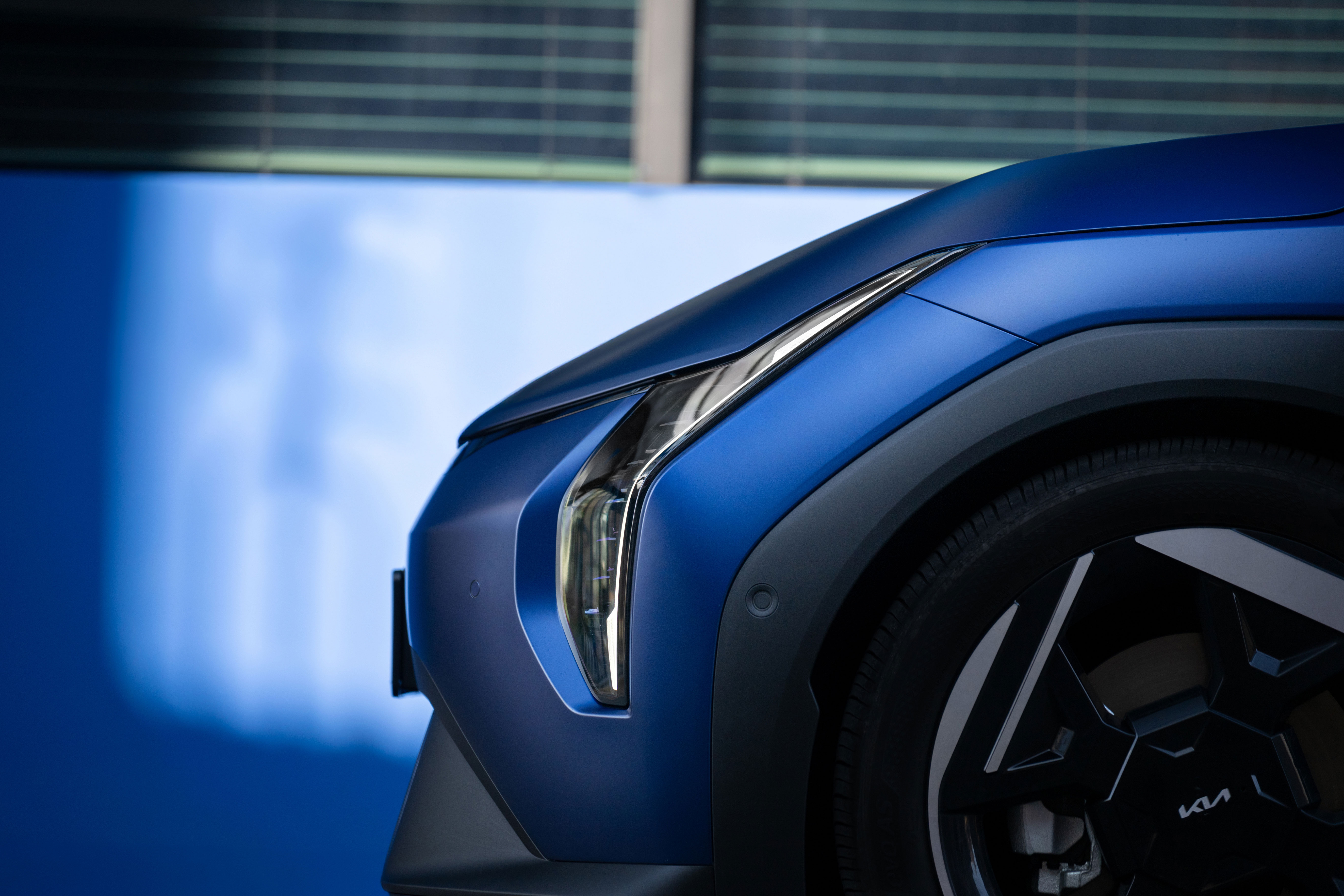 기아 EV4 차량의 전면 헤드램프와 앞바퀴가 부분 확대