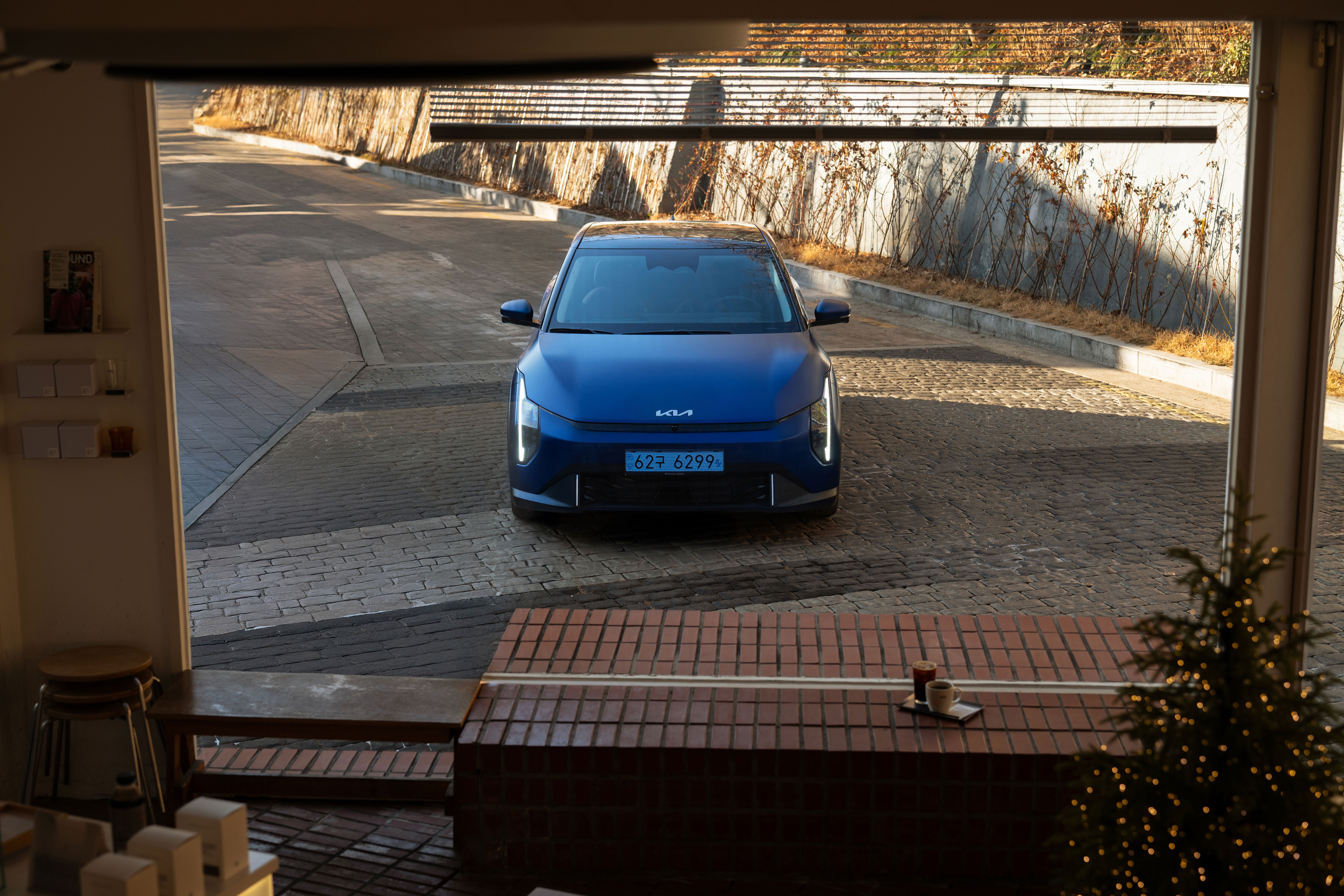 실내 창밖에서 바라본 기아 EV4 차량의 정면