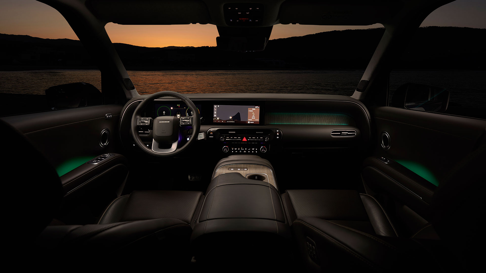 노을 풍경을 배경으로 현대자동차 디 올 뉴 팰리세이드 하이브리드 차량의 실내 앞좌석 전면