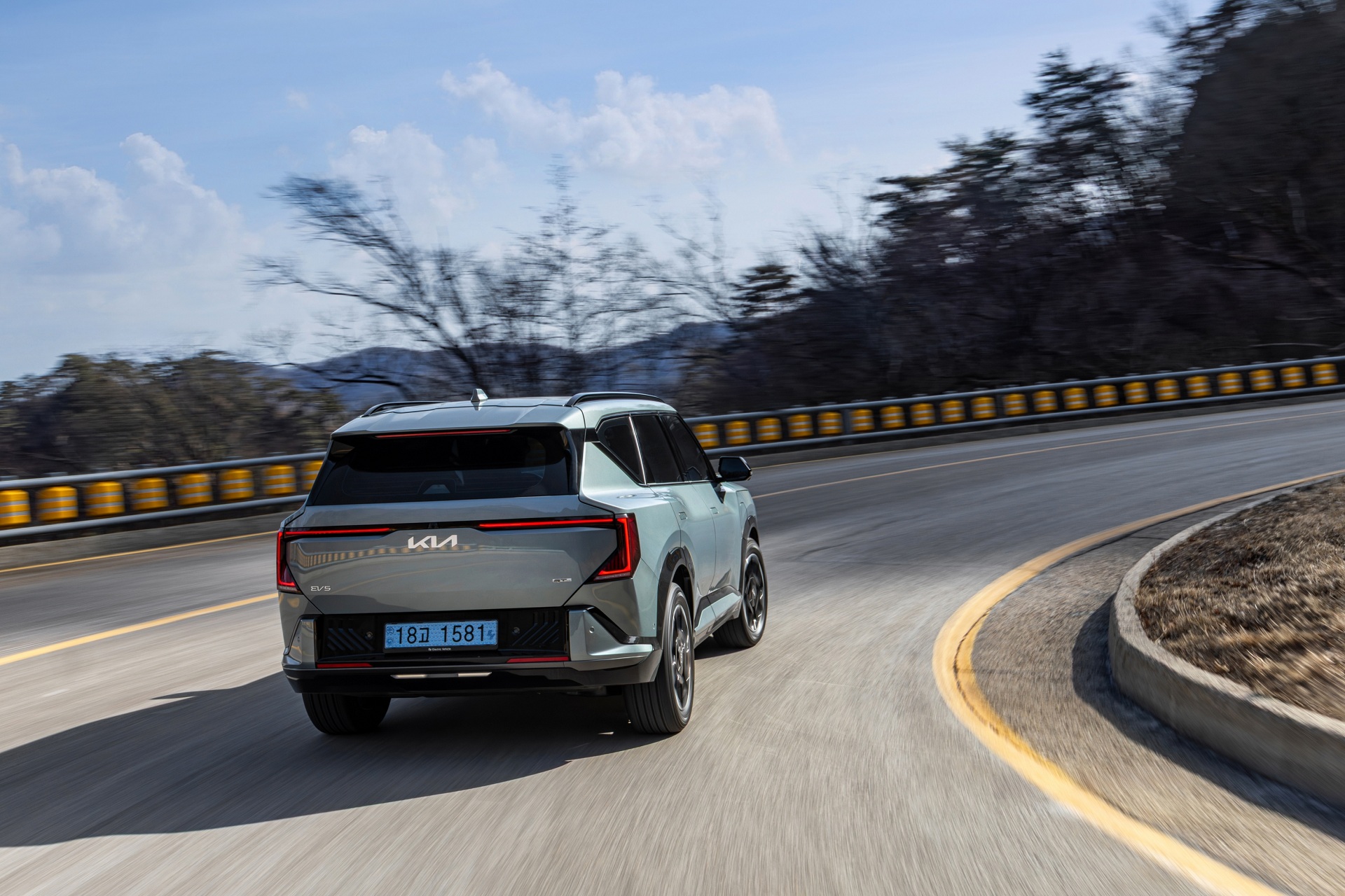 탁 트인 도로와 맑은 하늘 아래, 선명하게 드러나는 기아 EV5 GT-Line의 볼드한 실루엣.
