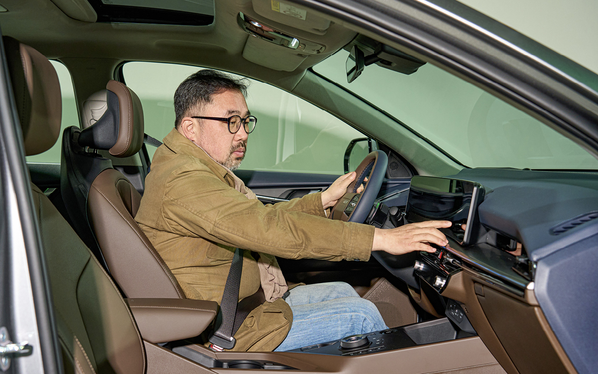 차량 실내를 살펴보는 자동차 칼럼니스트의 모습