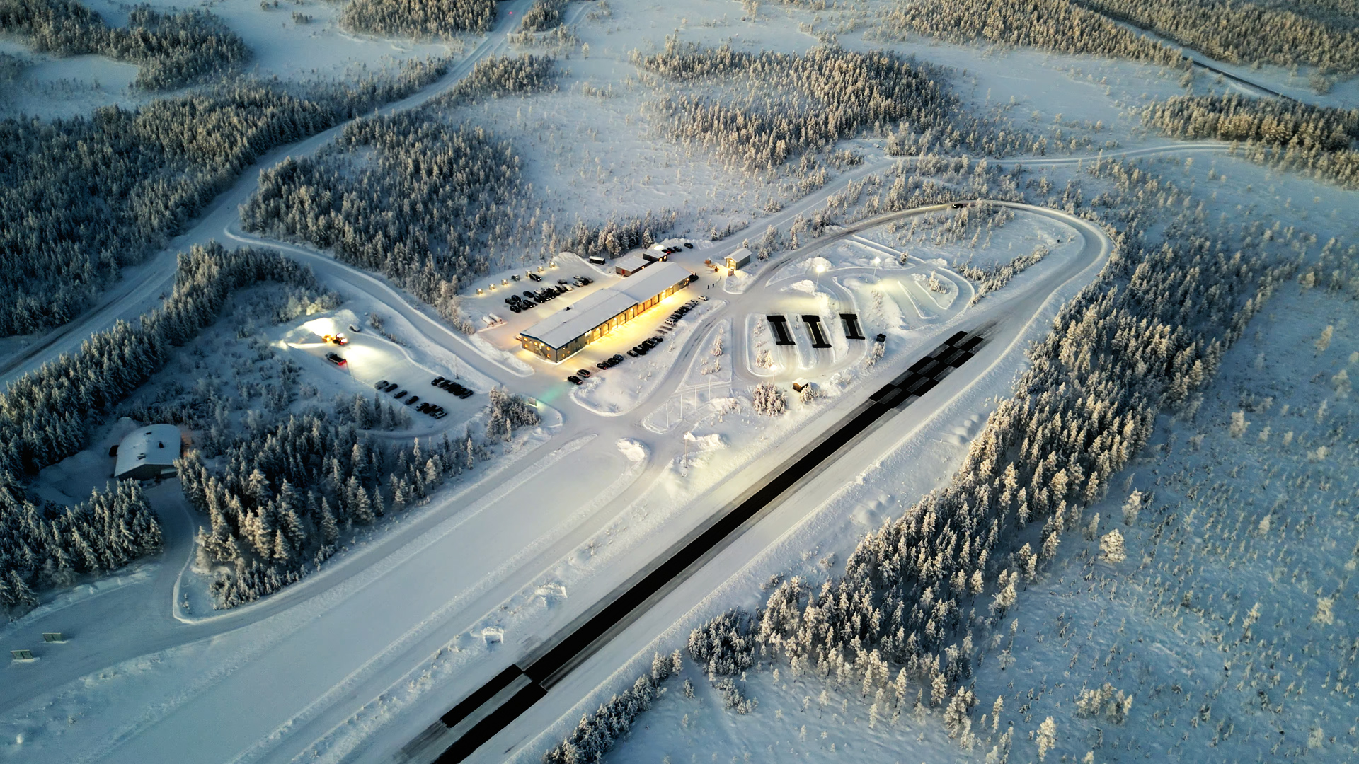 Aerial view of the Swedish winter testing ground surrounded by snowy forests and tracks