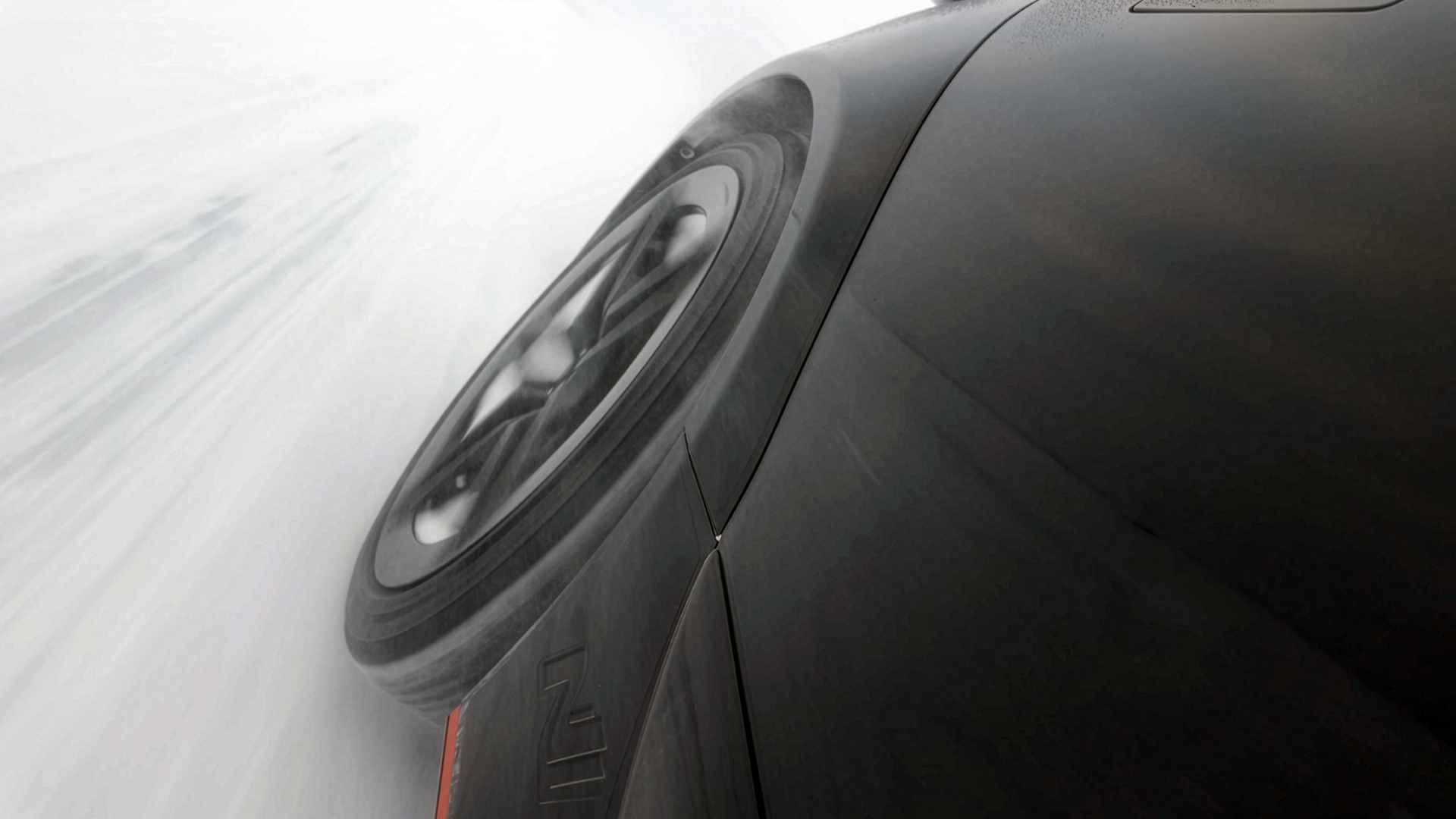 Close-up image of a tire driving on a snowy road surface