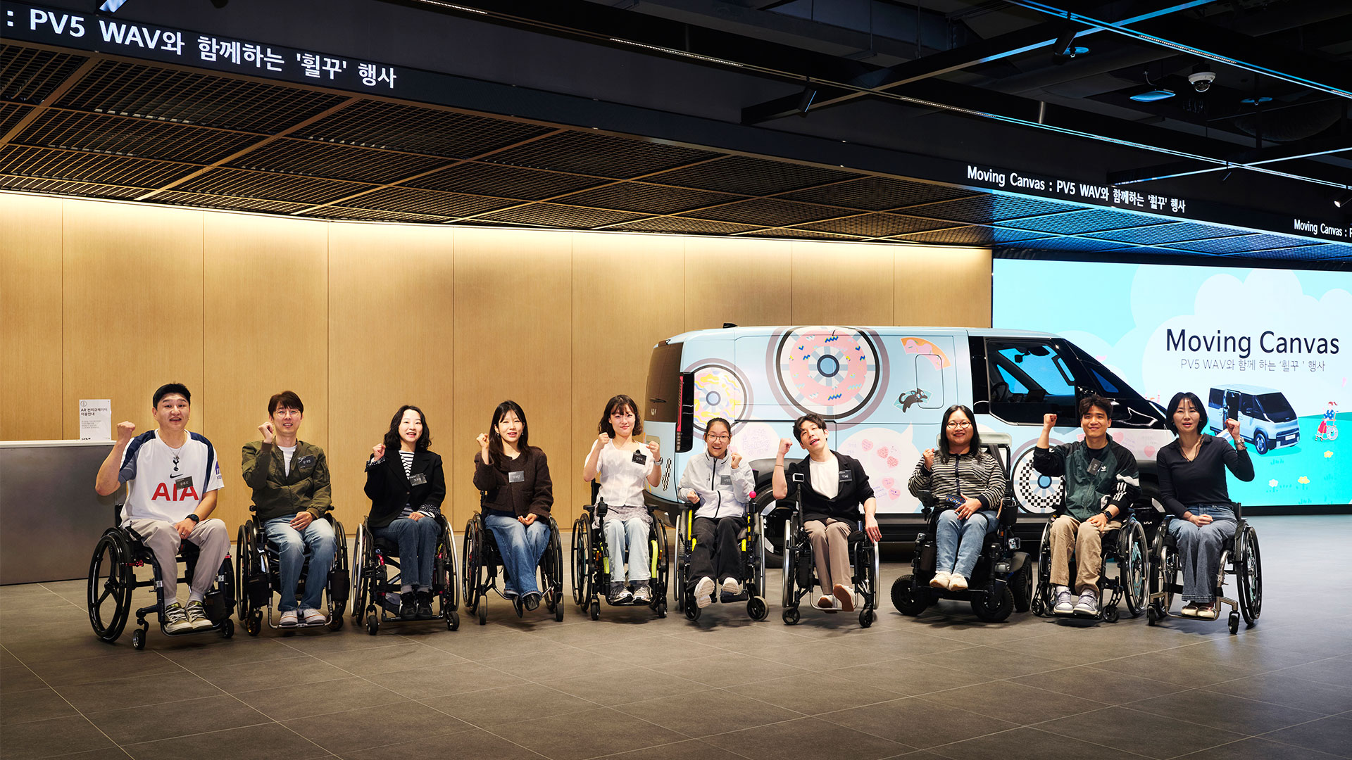 ) 4월 20일(월) 경기도 평택에 위치한 'PBV 익스피리언스 센터'에서 진행된 '무빙 캔버스 – PV5 WAV와 함께하는 휠꾸(휠체어 꾸미기)' 행사 참가자들이 기념촬영을 하고 있는 모습