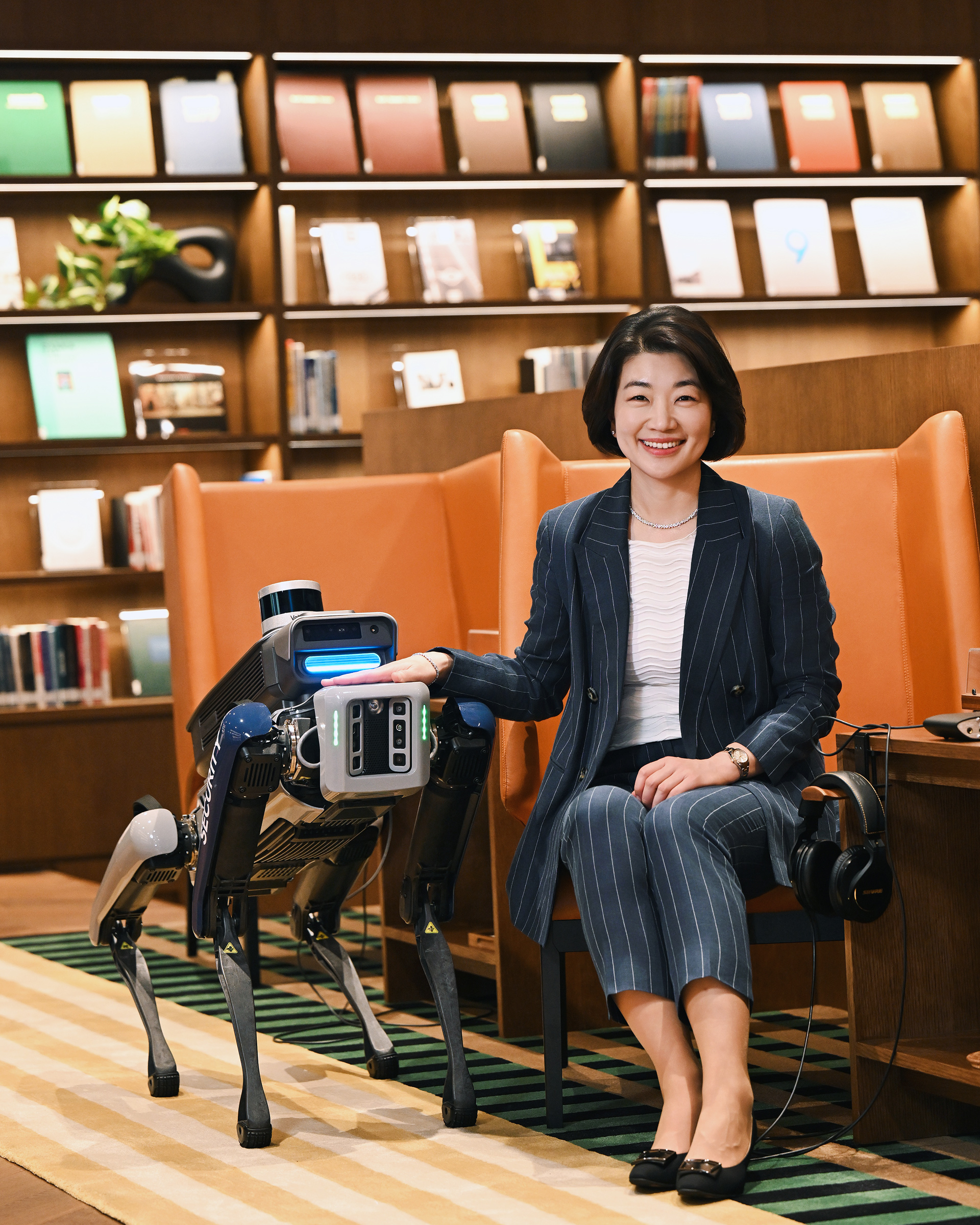 HMG CHRO Hae In Kim in an interview in a space with bookshelves and a sofa
