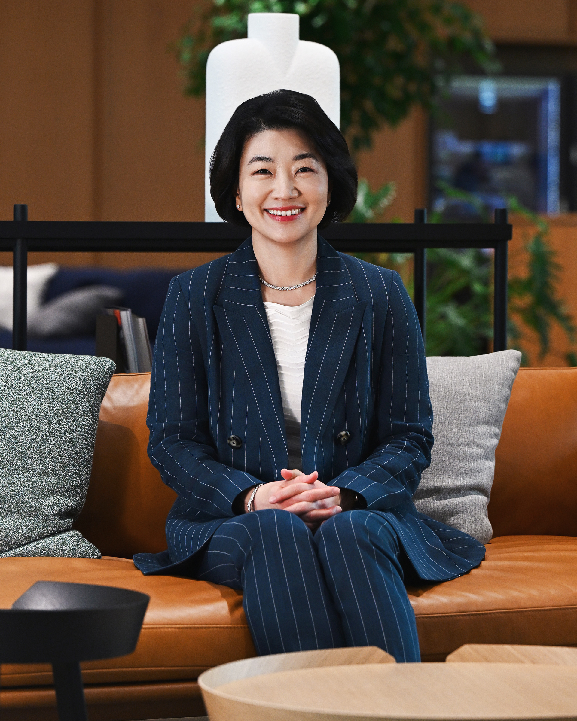 HMG CHRO Hae In Kim seated on a sofa