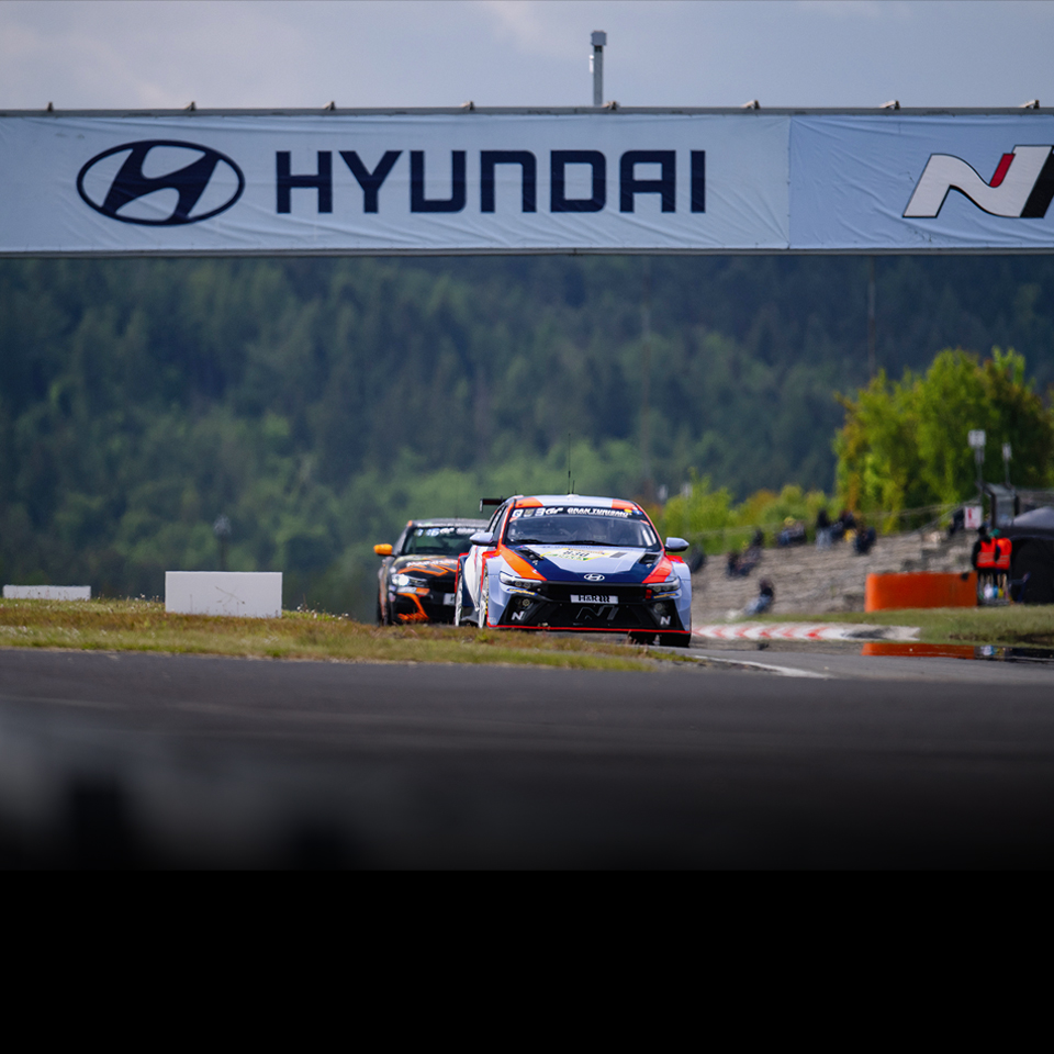 A Hyundai N race car speeding around the circuit during a race