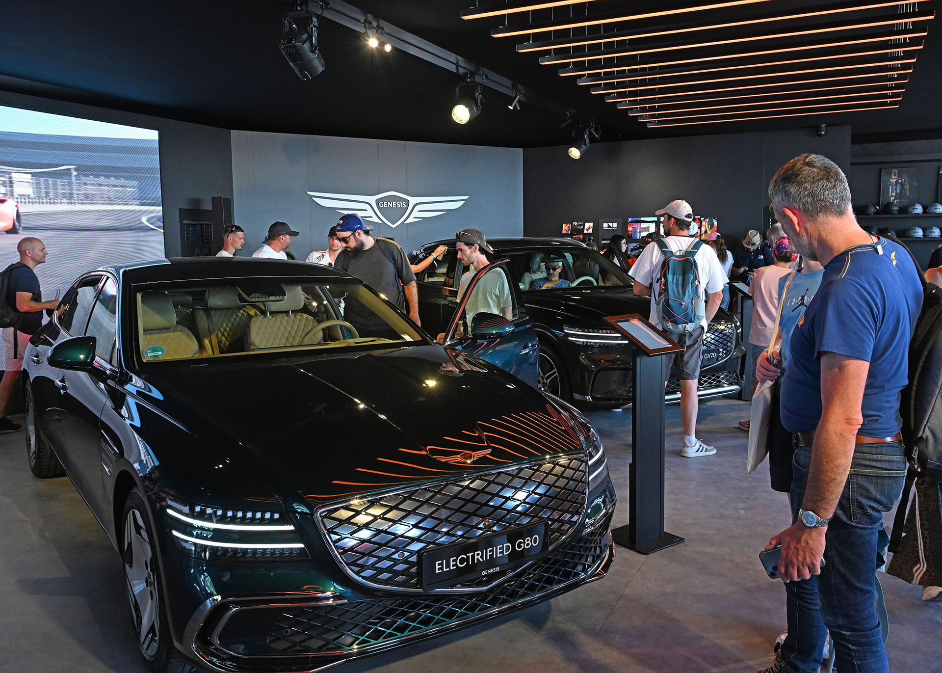 The front-side view of the Genesis G80 vehicle displayed in the exhibition hall.