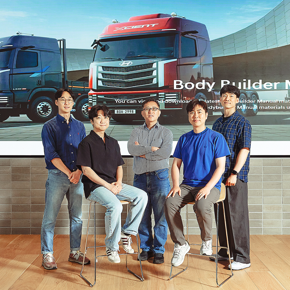 현대자동차 현대 컨버전 플러스 개발팀 직원들이 대형 상용차 이미지 앞에서 기념 촬영하는 모습