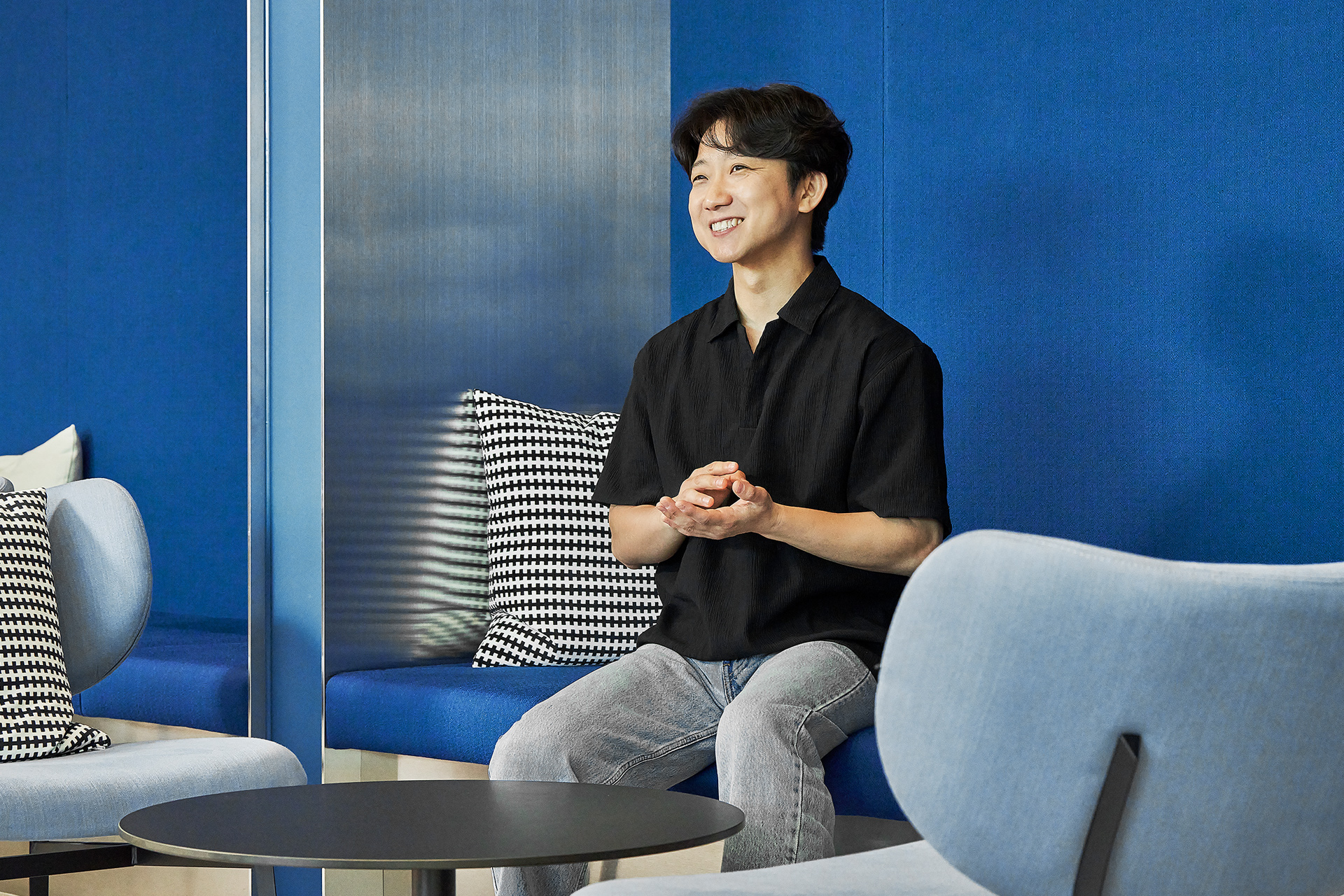 Yoon Myung-gun, Senior Manager, seated on a sofa during an interview
