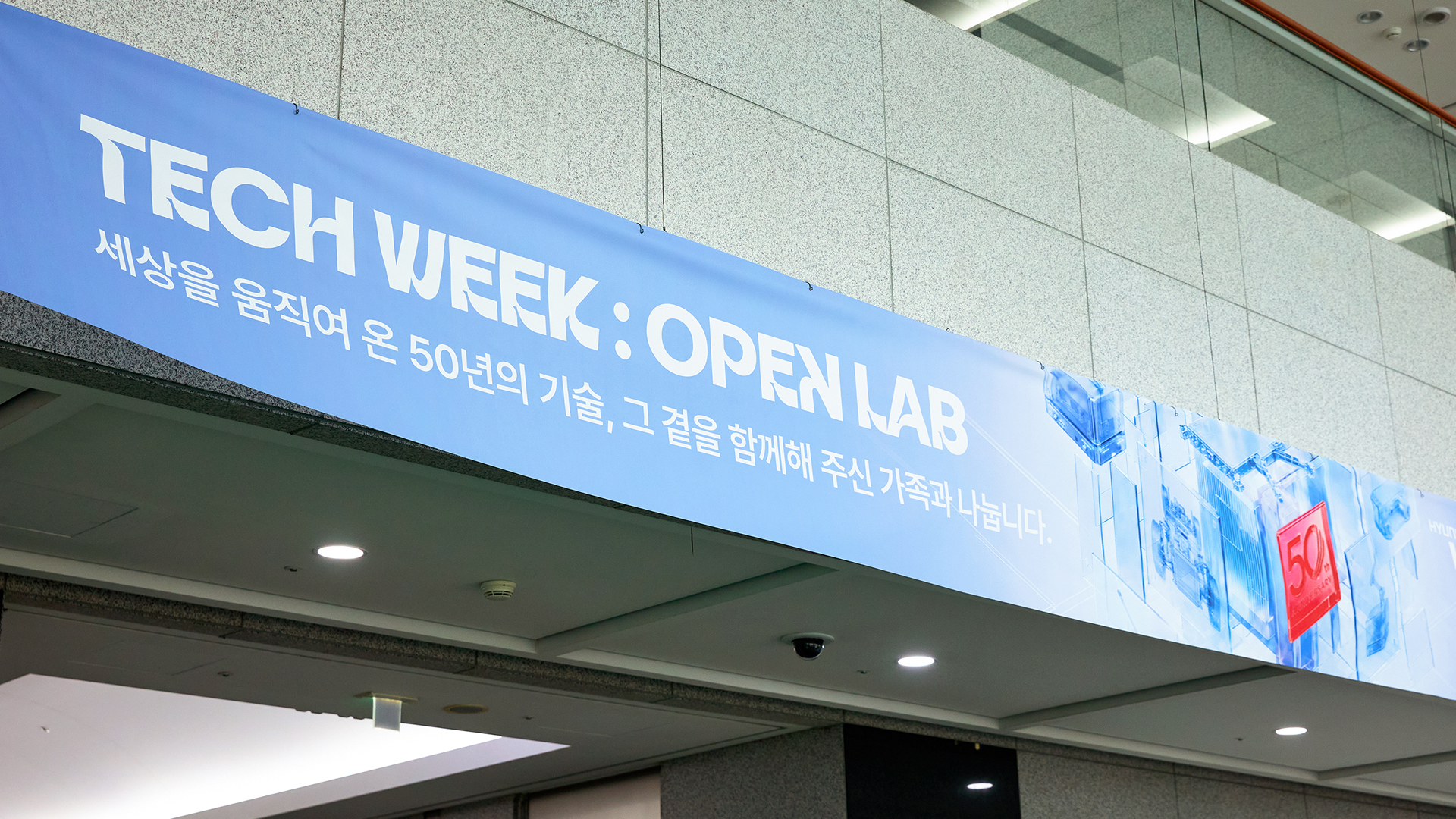 ‘TECH WEEK: OPEN LAB - 세상을 움직여 온 50년의 기술, 그 곁을 함께해 주신 가족과 나눕니다.’ 문구가 설치된 행사장