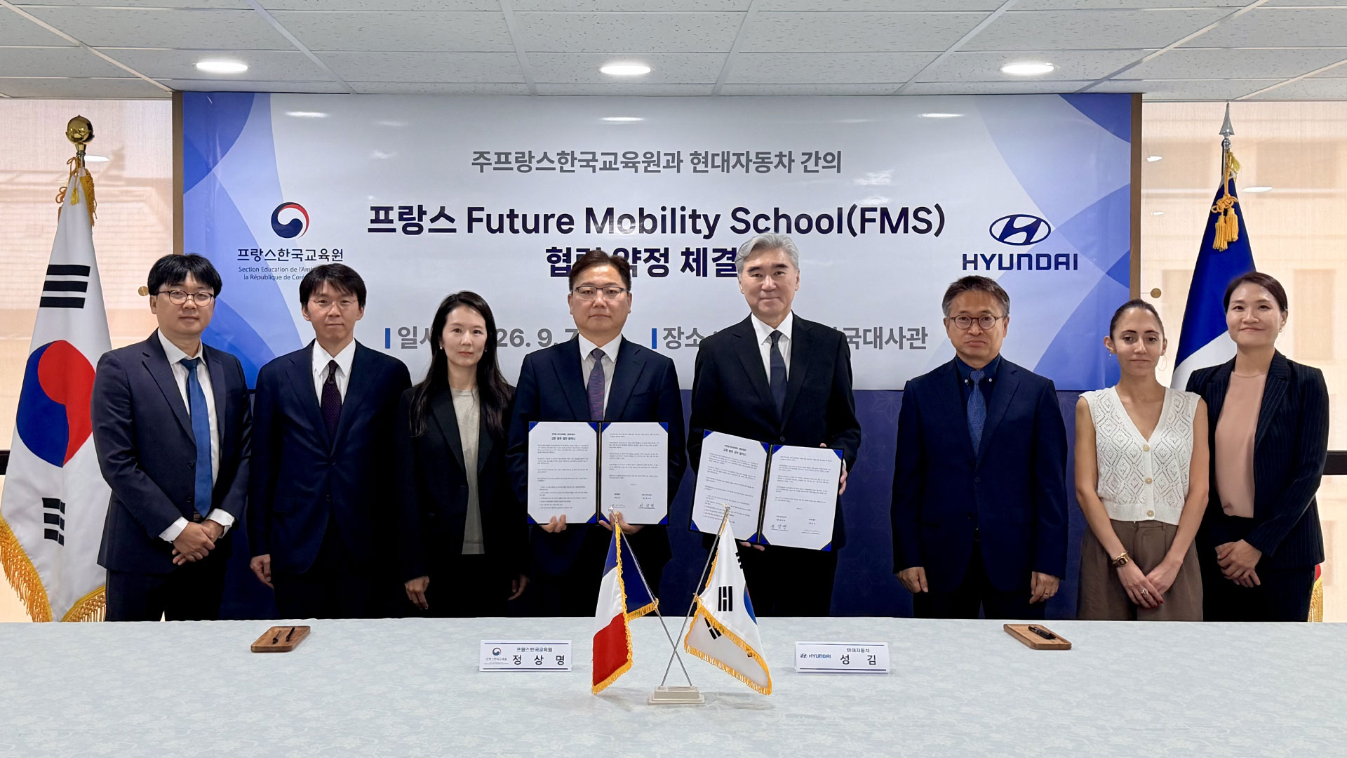 Director Sangmyeong Jeong of the Korean Education Center in France (fourth from the left) and Sung Kim, President and Head of Strategic Planning at Hyundai Motor Group (fifth from the left), are posing for a commemorative photograph.