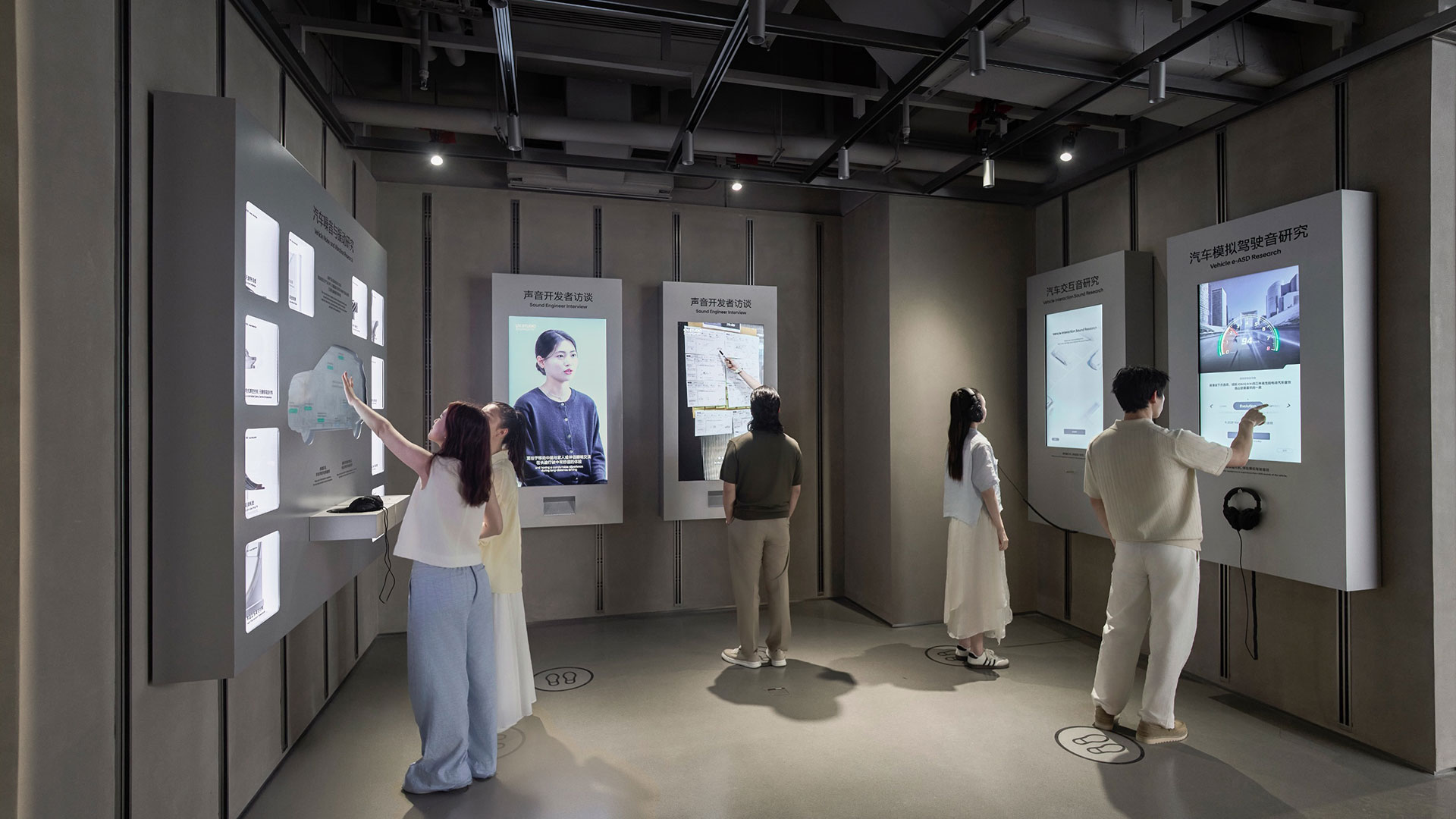 UX 아카이브 존에 설치된 벽면 키오스크에서 방문객들이 콘텐츠를 탐색하는 모습